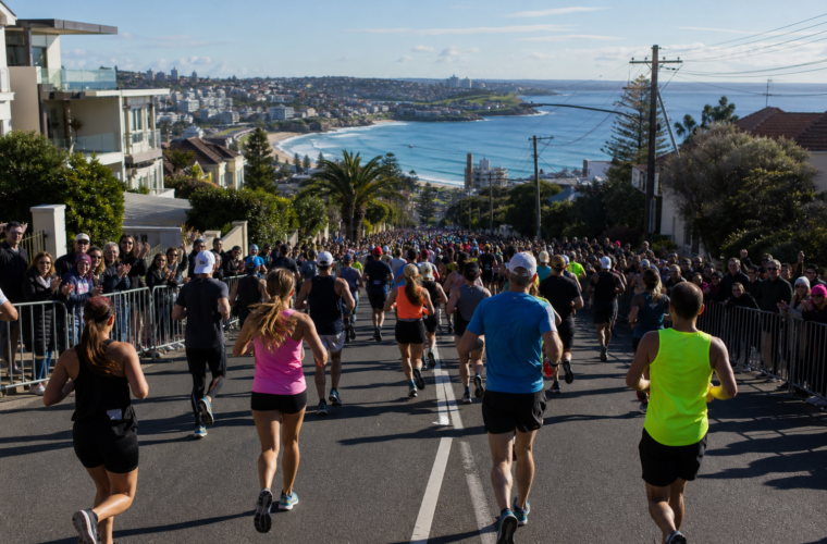 Runners descending an eastern Sydney road toward the coast during a large fun run